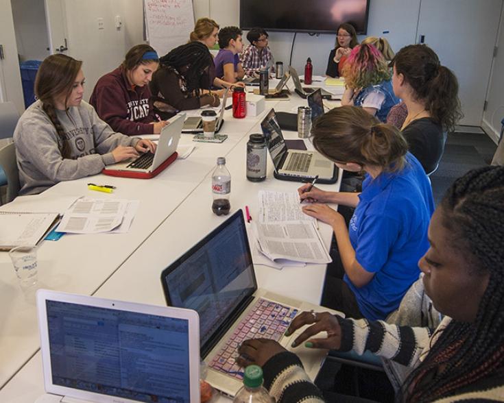 People seated at a table with laptops.